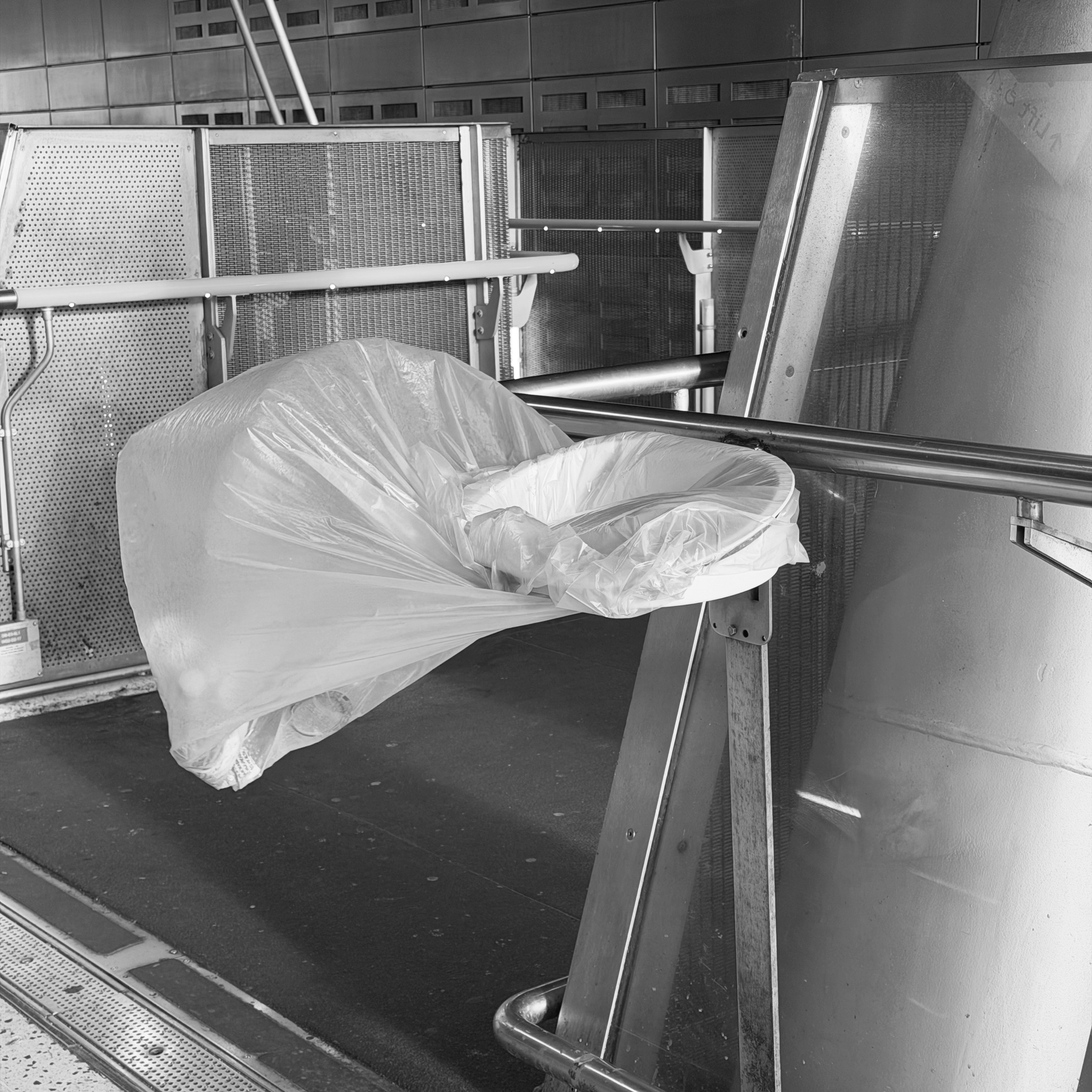 A plastic bin-bag is blown out of its holder.